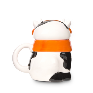 
                  
                    Mug shaped like a cow with an orange collar on a white background
                  
                