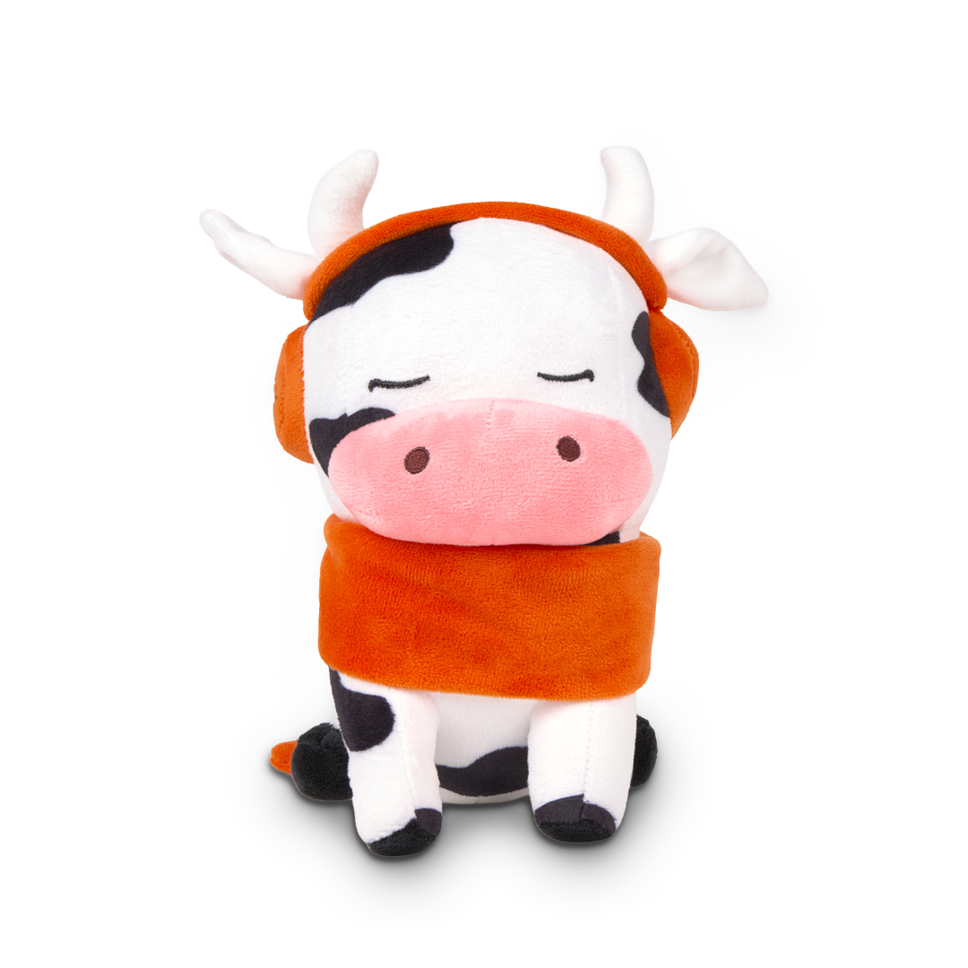 Plush toy cow with an orange scarf on a white background