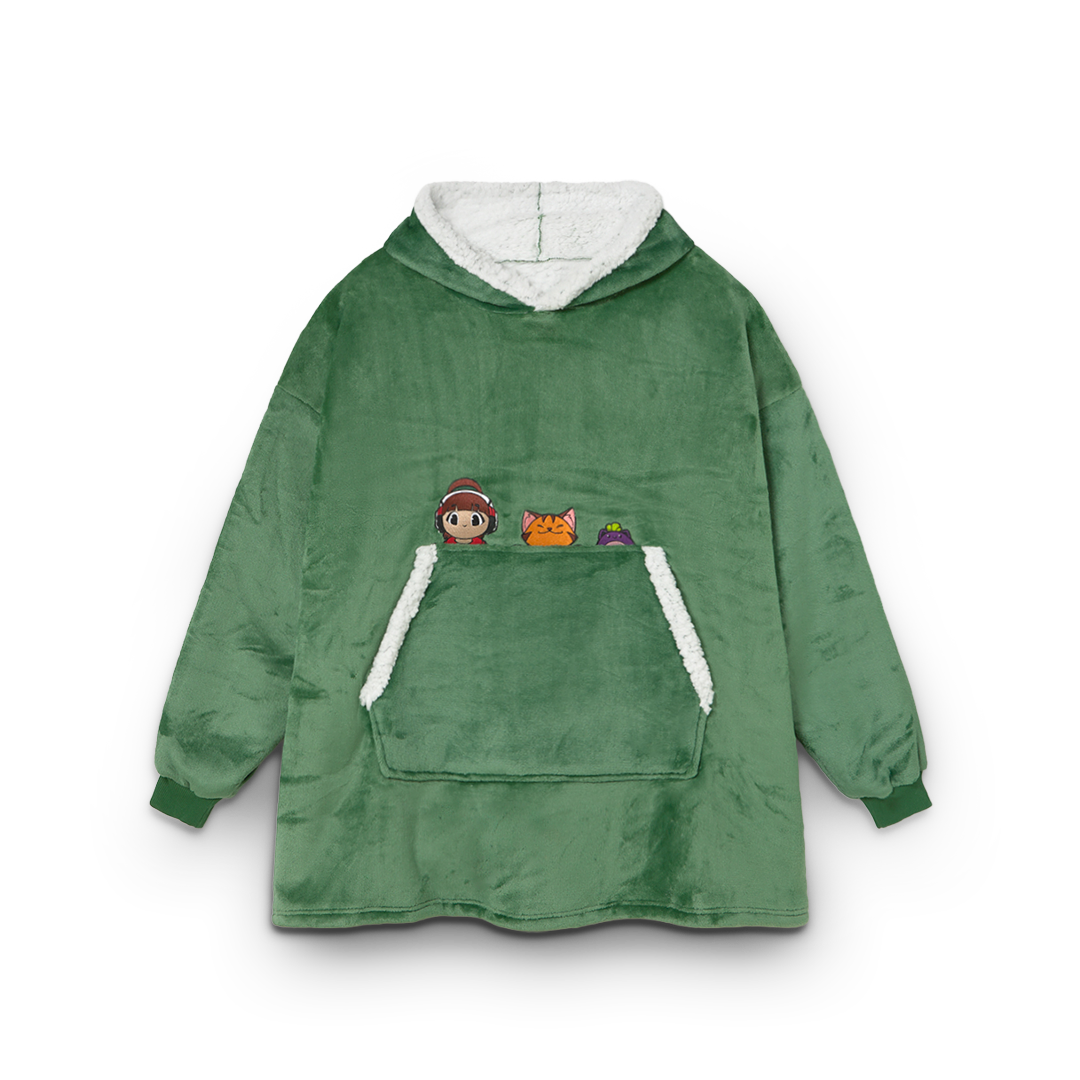 Green fleece poncho with cartoon character patches on a white background