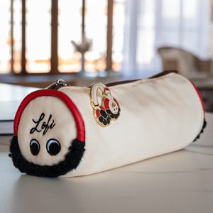 
                  
                    The image showcases a beautifully crafted pencil case designed to resemble headphones. With "Lofi" embroidered on one end, the pencil case features charming details like fluffy ear pads and a glossy pin shaped like classic headphones attached to the zipper, giving it a unique and playful look. The natural lighting in the background creates a cozy and inviting atmosphere, perfect for a study or creative session.
                  
                