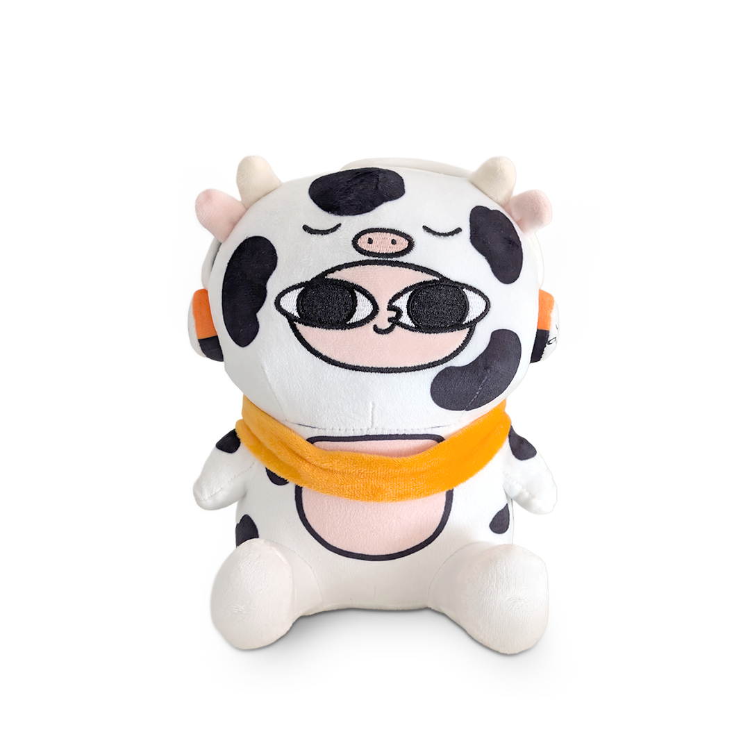 Plush toy cow with sunglasses and an orange bandana on a white background