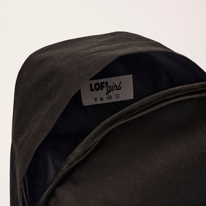 
                  
                    An interior view of the black Lofi Boy backpack, showing a label with "Lofi Girl" branding and care instructions inside the main compartment.
                  
                