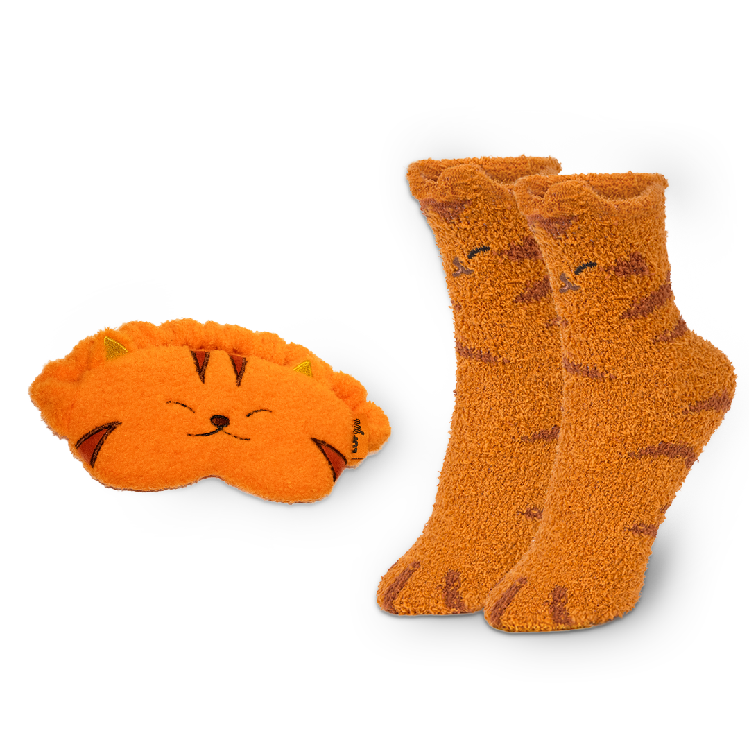 Pair of orange cat-themed socks and matching eye mask on a white background
