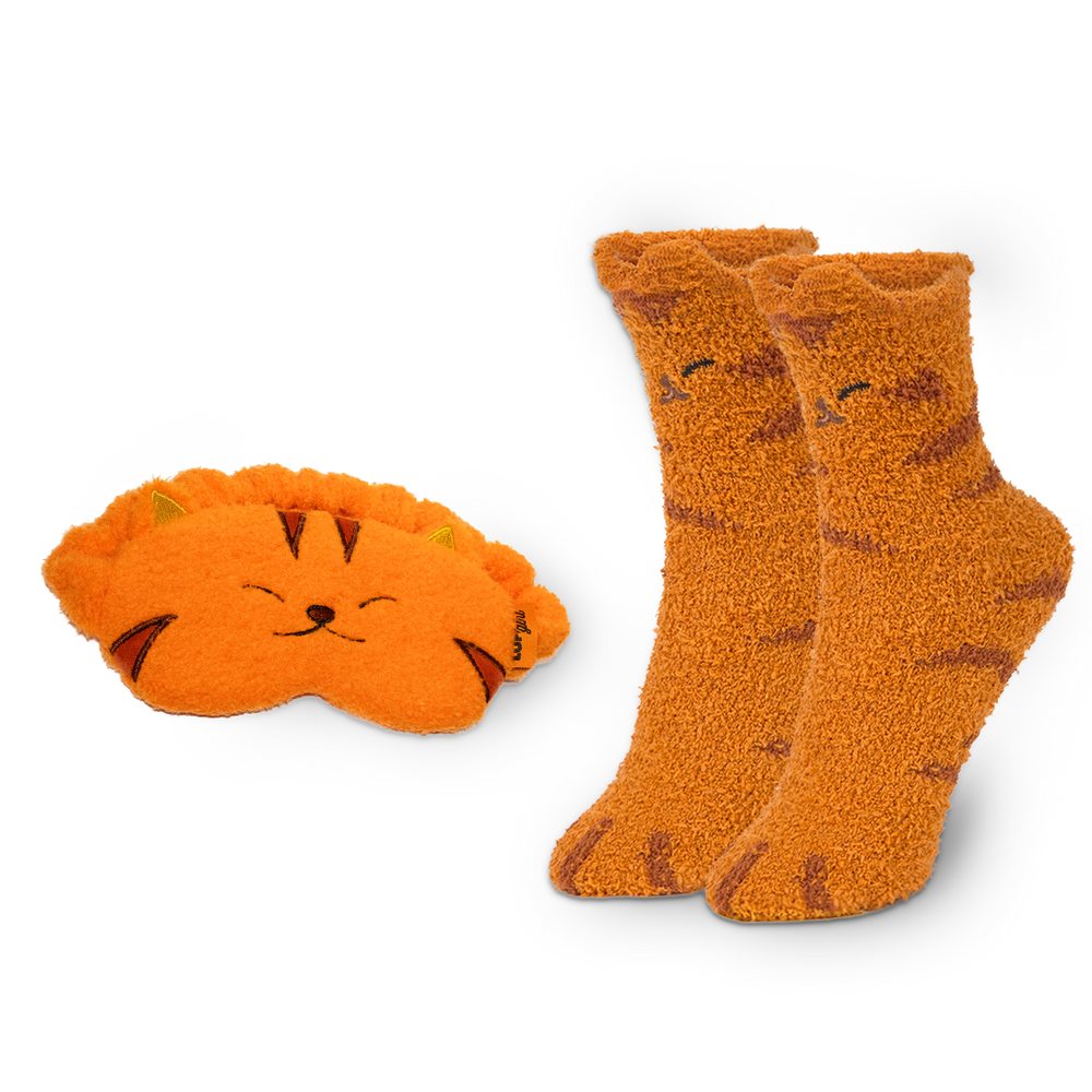 Pair of orange cat-themed socks and matching eye mask on a white background