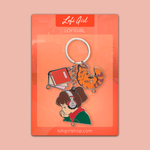 Keychain featuring Lofi Girl with headphones, a book, and a sleeping cat charm on a branded card backing.