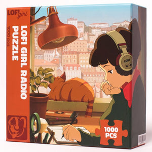 
                  
                    Front view of the Lofi Girl Radio Puzzle box, highlighting the detailed artwork of Lofi Girl wearing headphones, studying near a window with a sleeping cat in the background.
                  
                