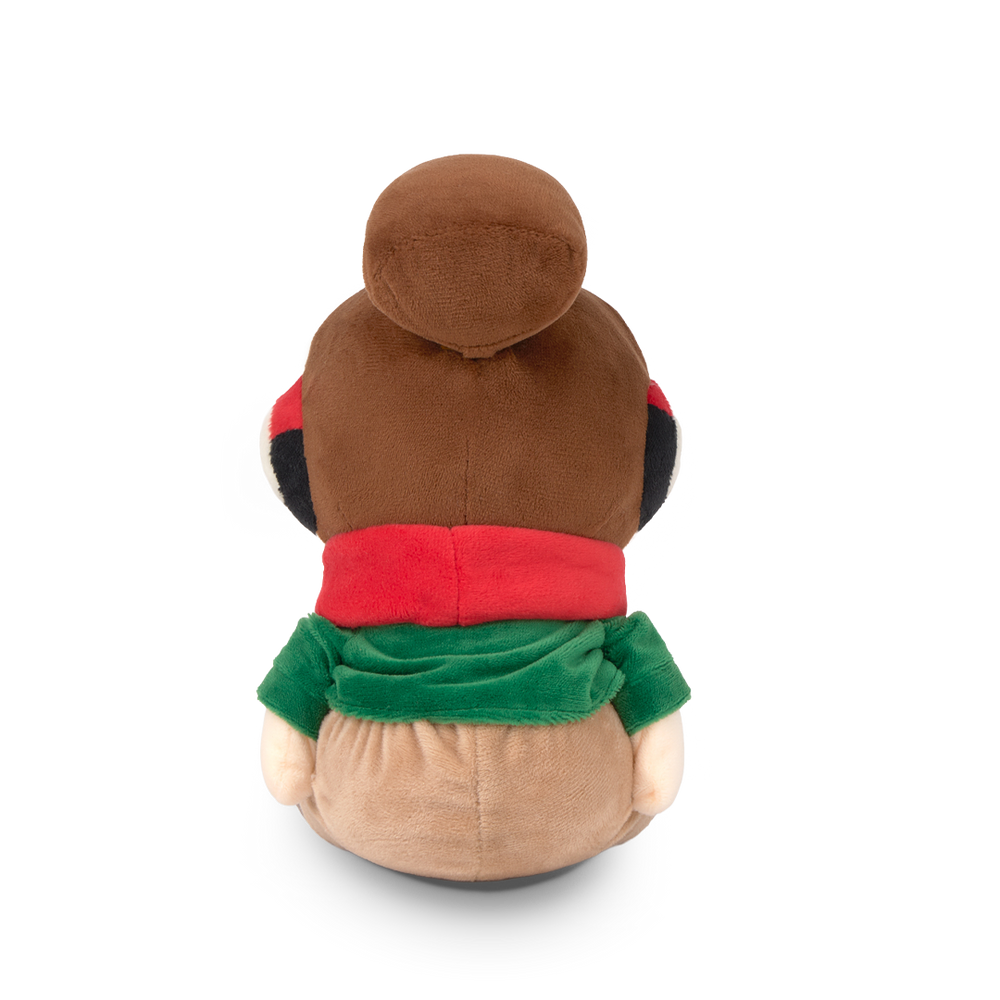 
                  
                    Plush toy with a brown body, red shirt, and green pants on a white background
                  
                