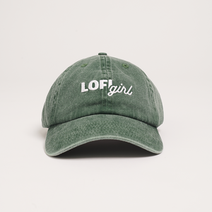 
                  
                    A front view of a vintage green cap laid flat, displaying the embroidered "Lofi girl" logo in white on the front panel. The cap has a slightly worn, faded appearance, highlighting its vintage style.
                  
                