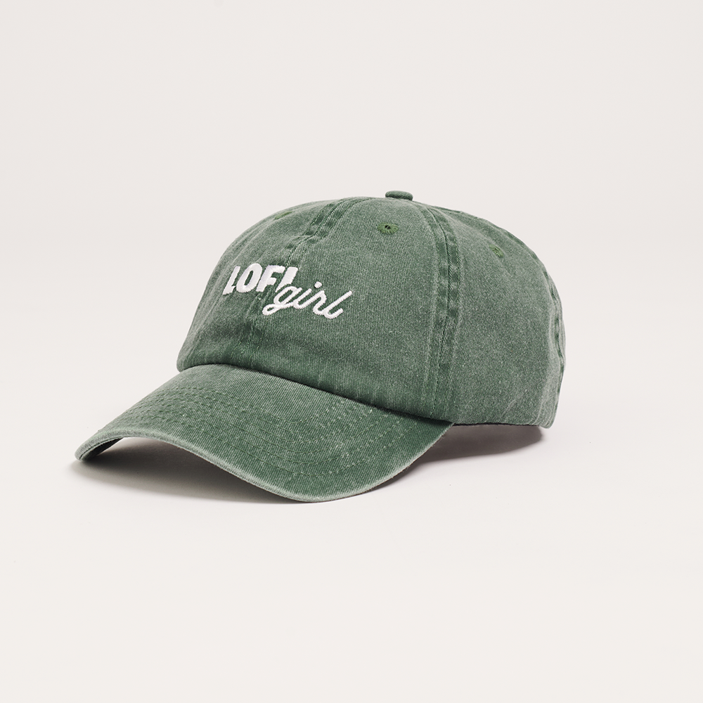 A side view of the vintage green cap, showing its curved brim and embroidered "Lofi girl" logo on the front. The cap's slightly faded and worn look gives it a classic vintage style.