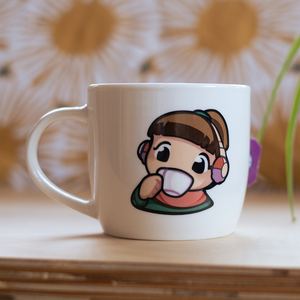 
                  
                    A white ceramic mug featuring an illustration of the Lofi Girl wearing headphones, sipping from a cup. The background shows a soft focus with a flower-like pattern.
                  
                